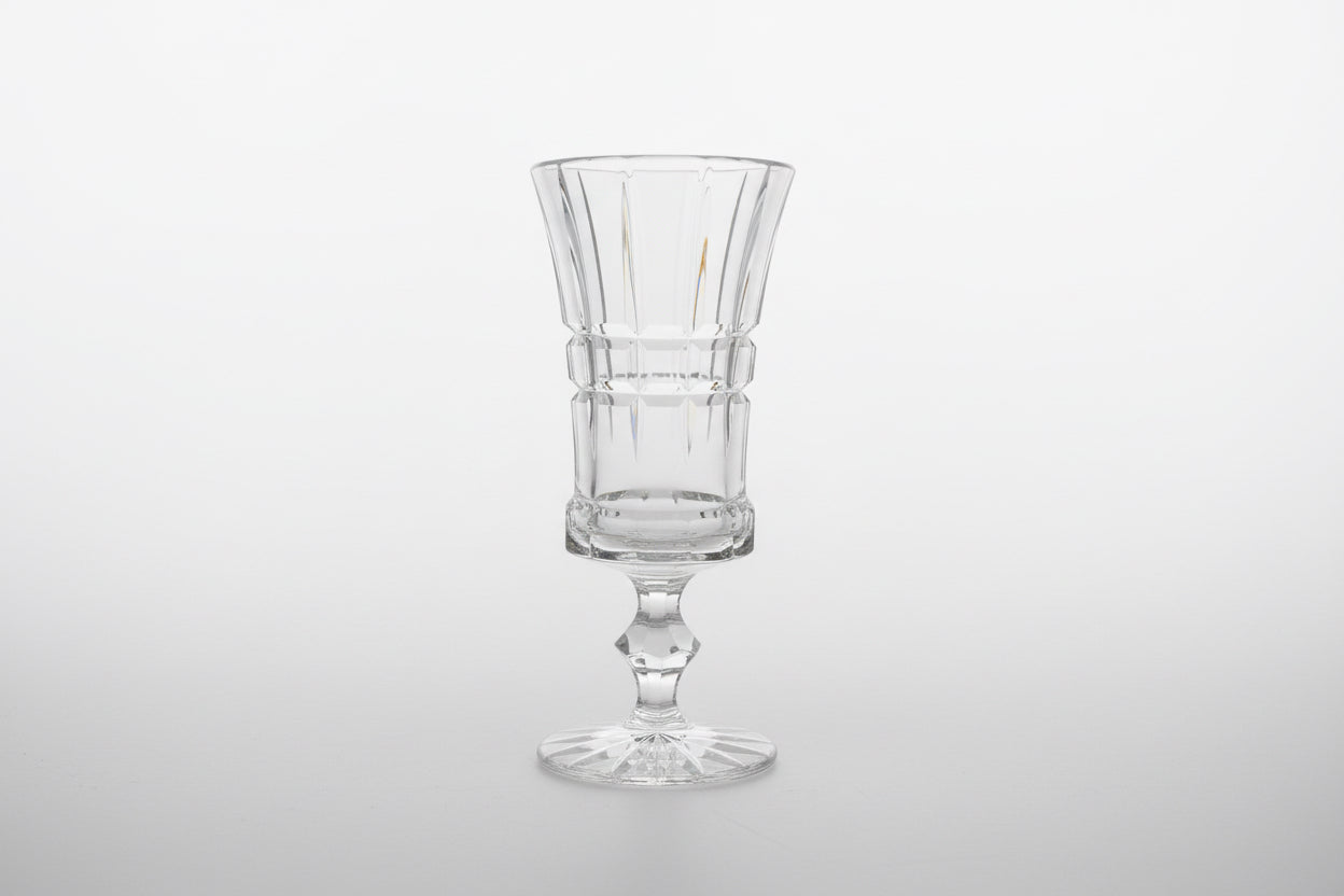 Clear crystal pedestal vase by The Vault Creative, showcasing a tall, elegant glass vessel with a wide base and slender neck.