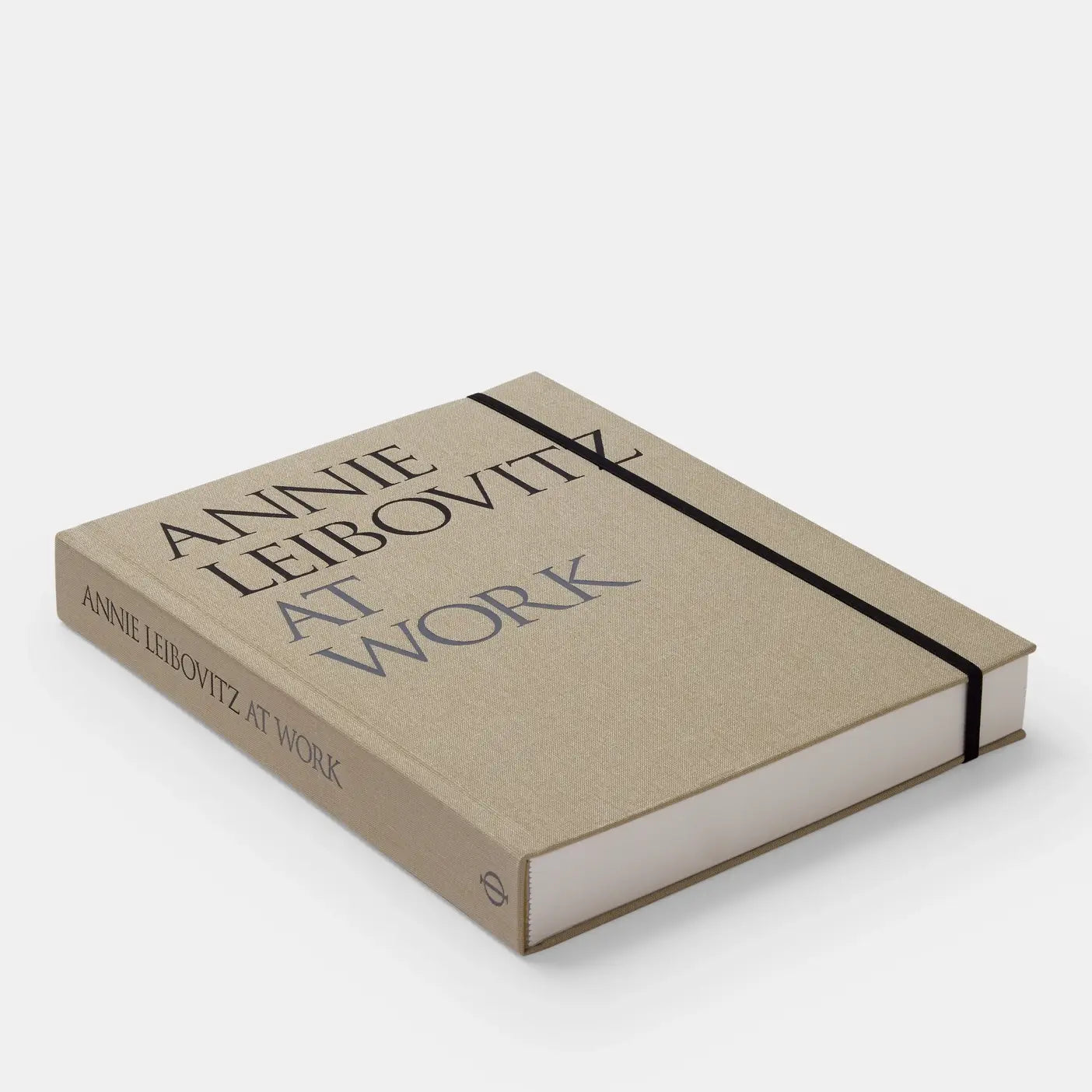 Annie Leibovitz At Work book by Phaidon showing a close-up of the hardcover with a black-and-white portrait on the cover.
