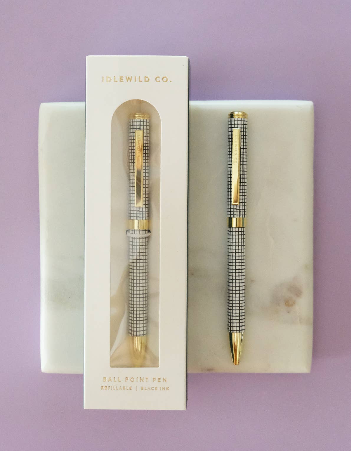Idlewild Co. Grid Ballpoint Luxe Pen with black ink and sleek design, shown resting on a white surface.