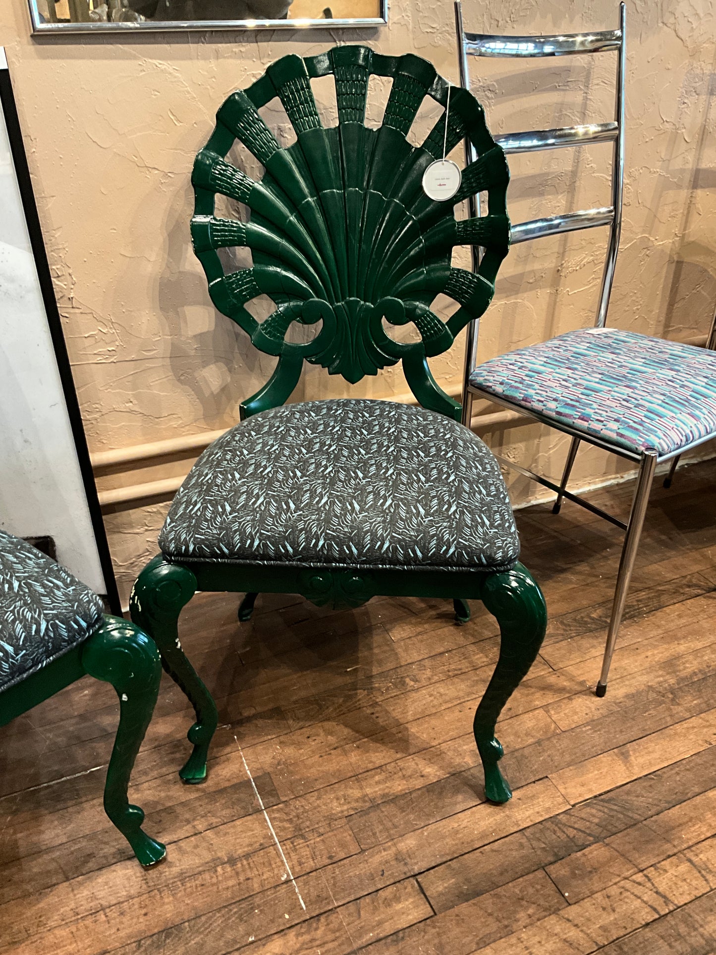 Green shell chair by The Vault Creative with smooth curves and vibrant upholstery, perfect for modern interior decor.