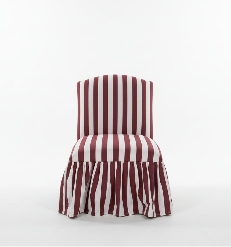 Pink and fuchsia striped fabric chair with a skirt, designed by The Vault Creative, showcasing stylish and vibrant home seating.