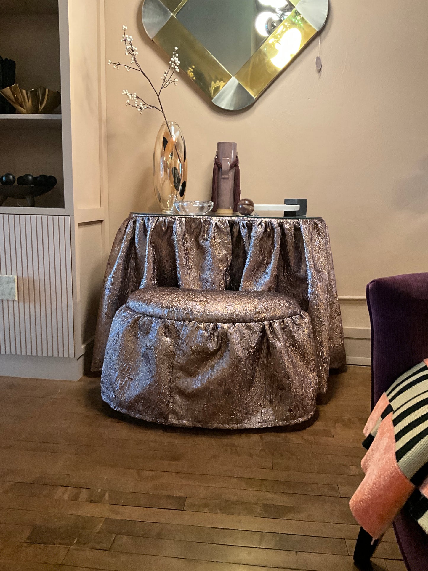 Vintage skirted vanity by Ozmun Home featuring a wooden tabletop, ornate legs, and a built-in mirror with decorative detailing.