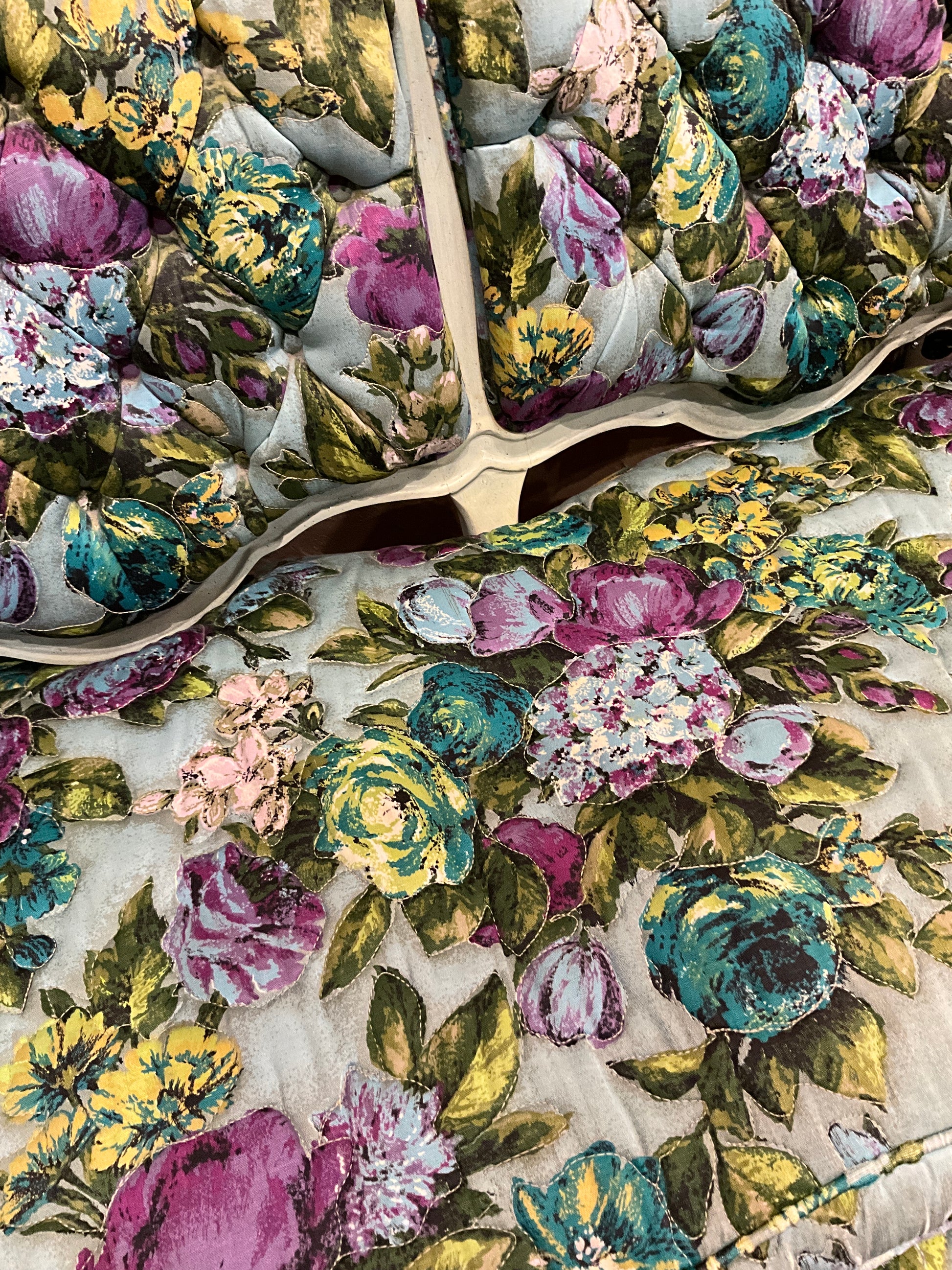 Small floral loveseat bench by The Vault Creative with colorful fabric and cushioned seating, ideal for compact living spaces.