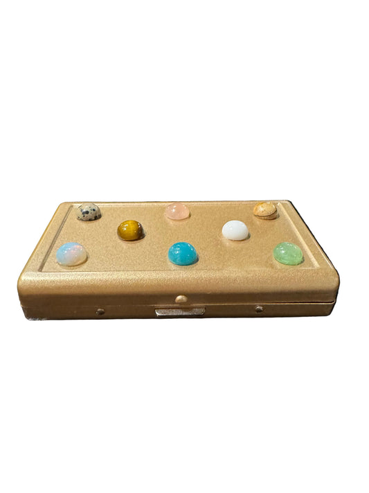 Multicolor cigarette case by The Vault Creative, P.Grunsfeld Light design, with sleek metal exterior and colorful interior for storage.