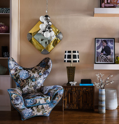 Floral wing back chair by The Vault Creative with colorful fabric upholstery and classic winged design.