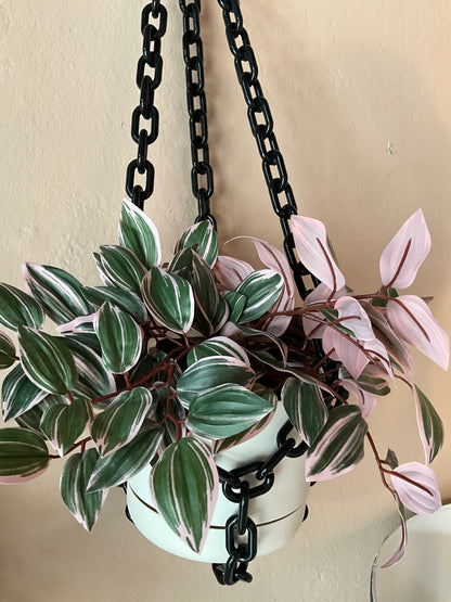 Black chain hanging planter by The Vault Creative with a round container and sturdy chain for indoor or outdoor plant display.