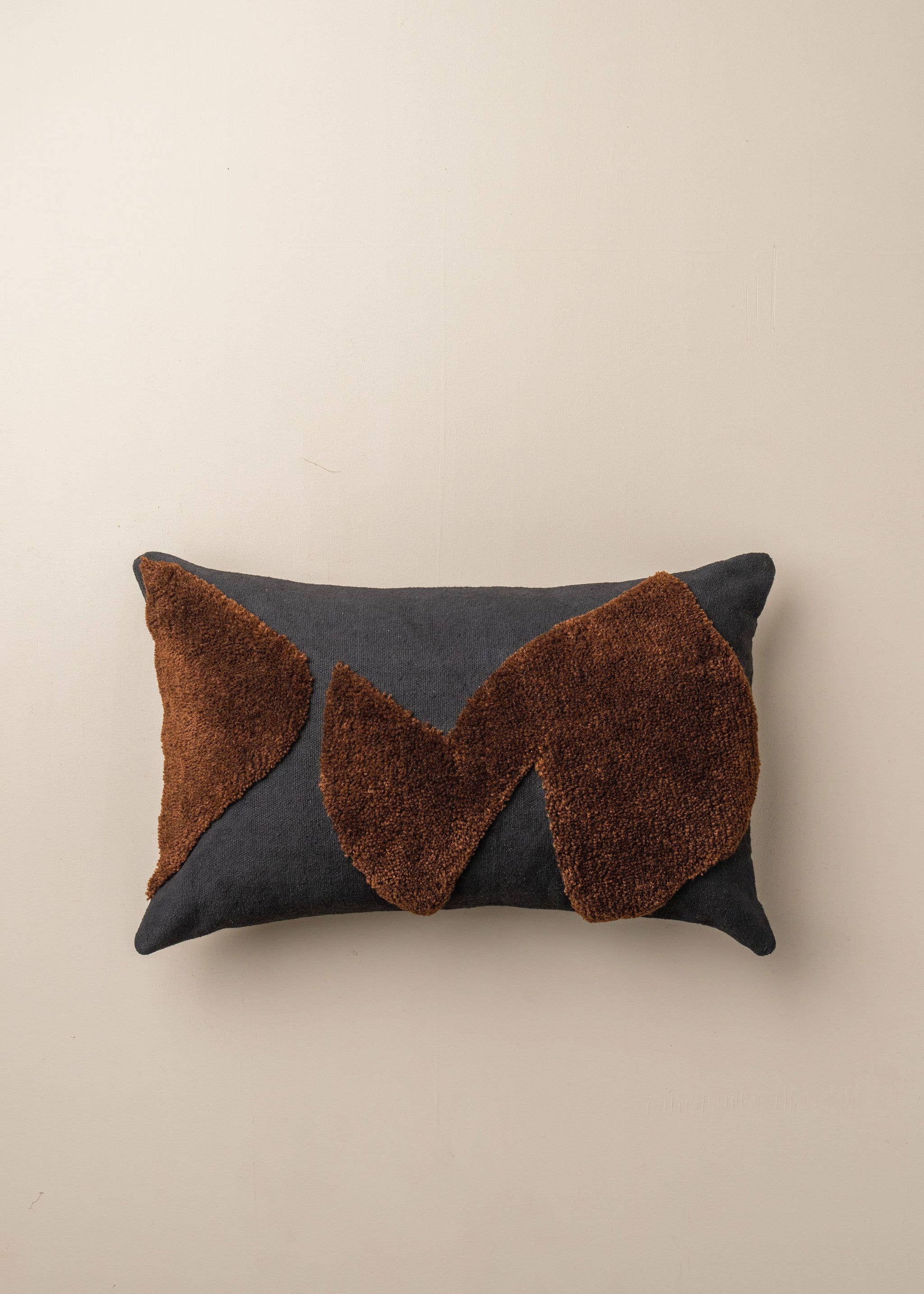 Abstract cushion in black and chocolate with modern design, by Saardé, featuring soft fabric and artistic patterns.