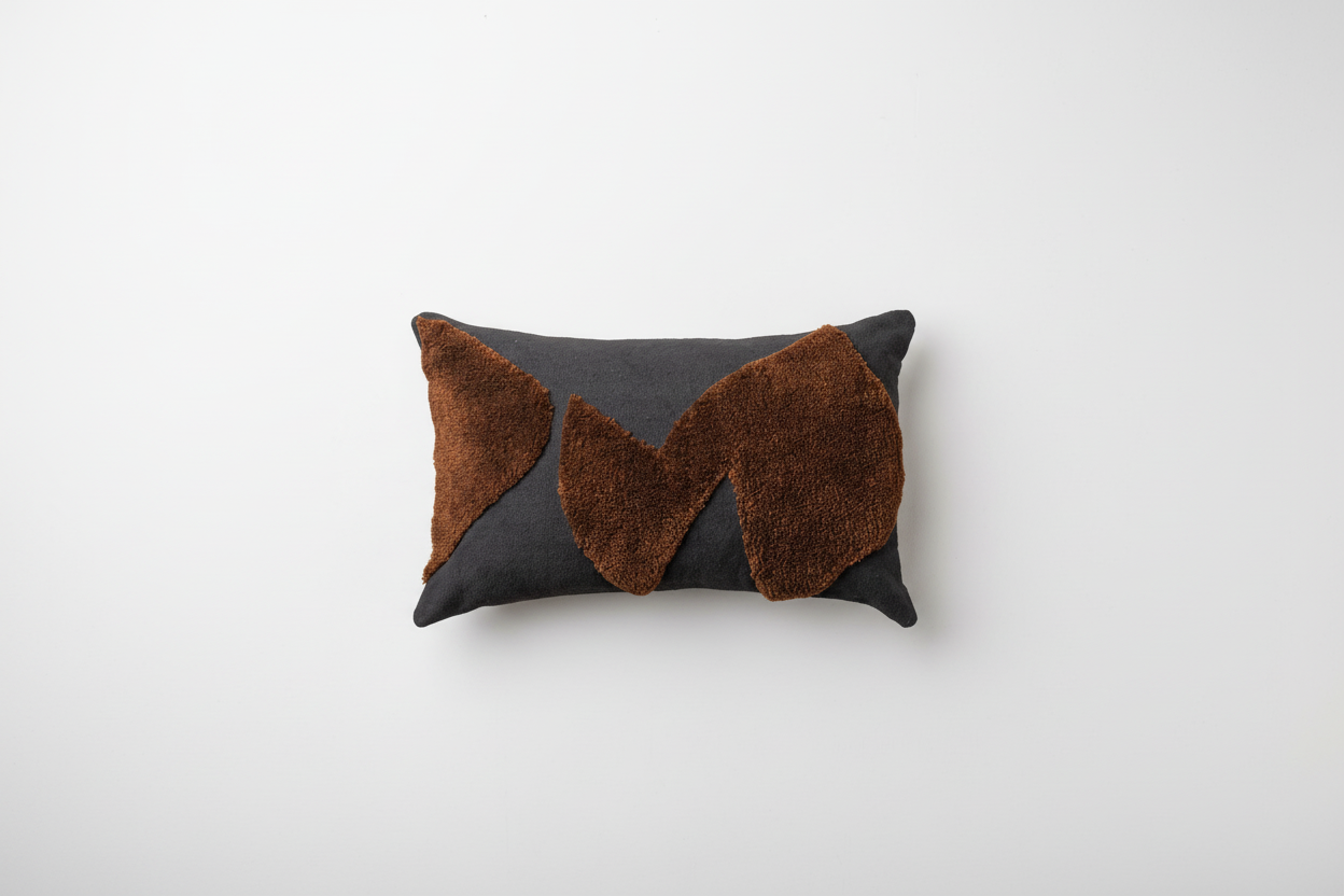 Abstract cushions by Saardé in black and chocolate with modern, artistic design, showcasing textured fabric and decorative appeal.