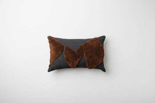 Abstract cushions by Saardé in black and chocolate with modern, artistic design, showcasing textured fabric and decorative appeal.