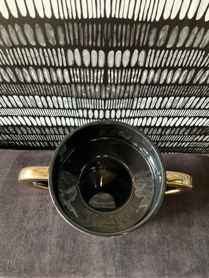 Black and gold ceramic vase by The Vault Creative featuring elegant design and a glossy finish.