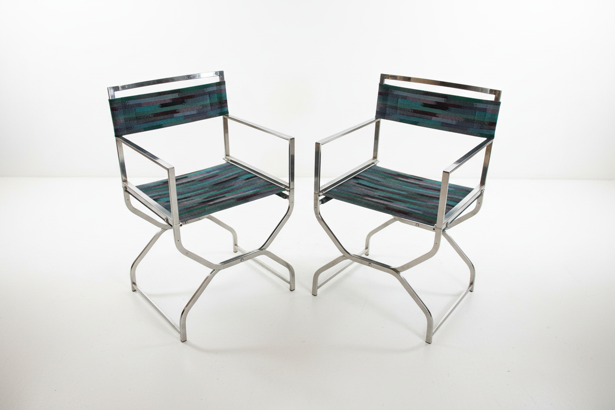 Pair of vintage chrome directors chairs with black fabric seats and wooden armrests, stylish retro seating from The Vault Creative.