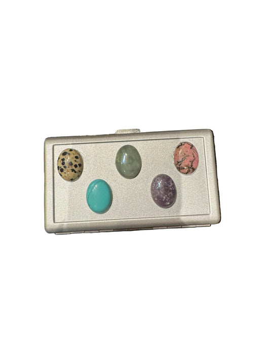 Silver cigarette case by The Vault Creative featuring colorful gem accents and a sleek, elegant design.