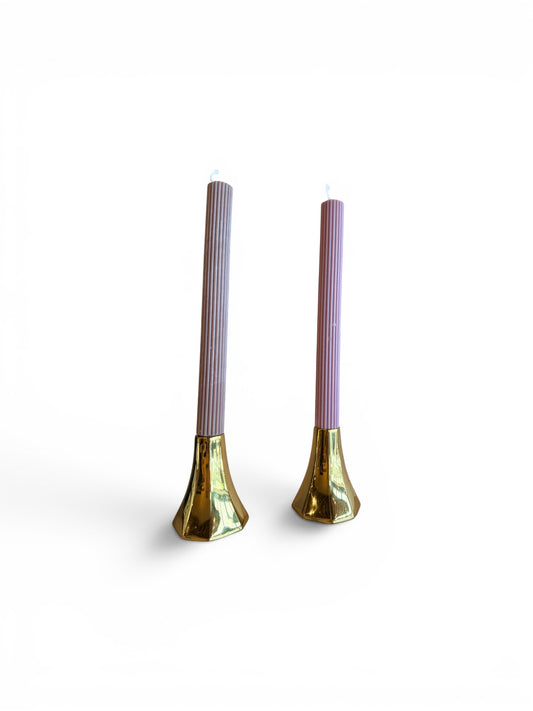 Set of three polished brass tapered candle holders with sleek, modern design and smooth finish, perfect for tabletop decor.