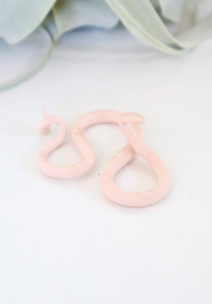 Colorful grapefruit snake sculpture by The Vault Creative, featuring vibrant orange and pink hues and a textured, coiled design.