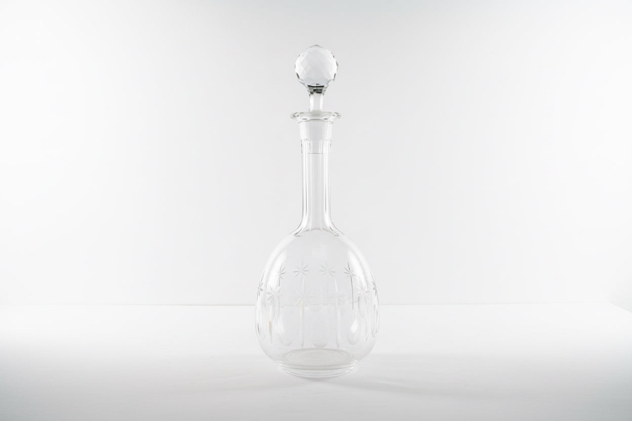 French crystal decanter by The Vault Creative with a classic design and elegant glass stopper on a wooden surface.