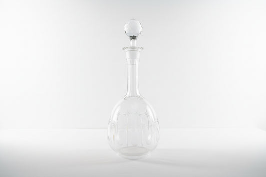 French crystal decanter by The Vault Creative with a classic design and elegant glass stopper on a wooden surface.