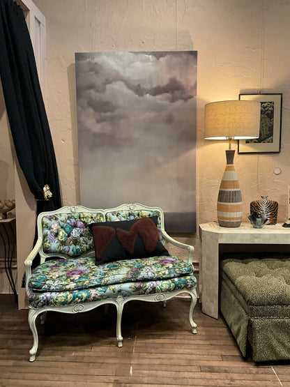 Small flower loveseat bench by The Vault Creative with floral upholstery and wooden legs, ideal for compact living spaces.