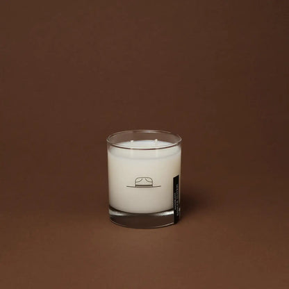 Ozmun Home Superbloom Candle in a glass jar with colorful floral design and a lit wick, creating a cozy and inviting ambiance.