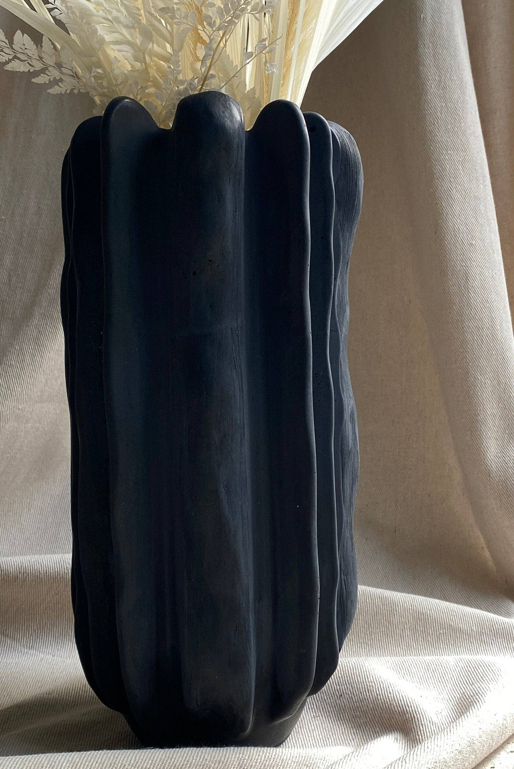 Concrete vase by Atelier La Rouleuse with a modern, minimalist design, featuring a smooth, cylindrical shape and neutral gray finish.