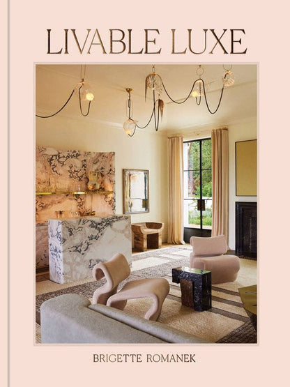 Open book titled Livable Luxe by Chronicle Books, showing colorful interior pages with stylish decor and design ideas.