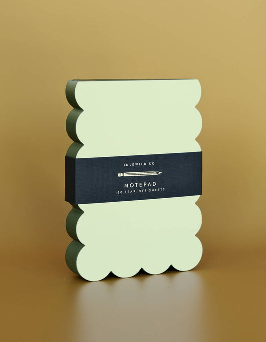 Scalloped shaped notepad with chartreuse and olive edge from Idlewild Co., displaying the distinctive scalloped design and vibrant colors.