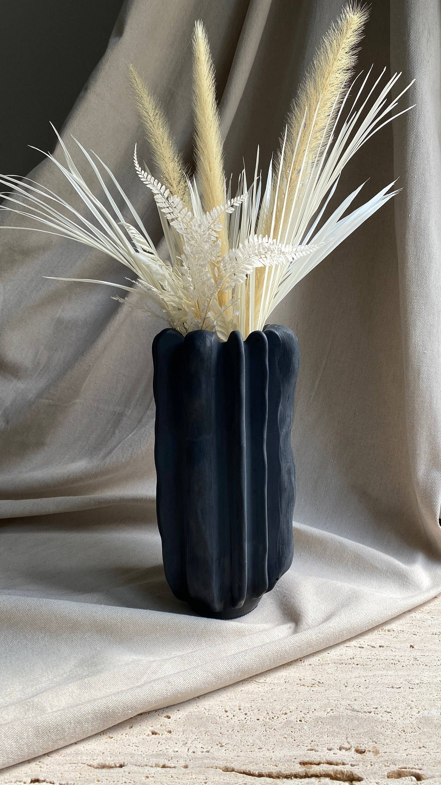 Forma concrete vase by Atelier La Rouleuse with a modern, minimalist design featuring a smooth, textured surface.