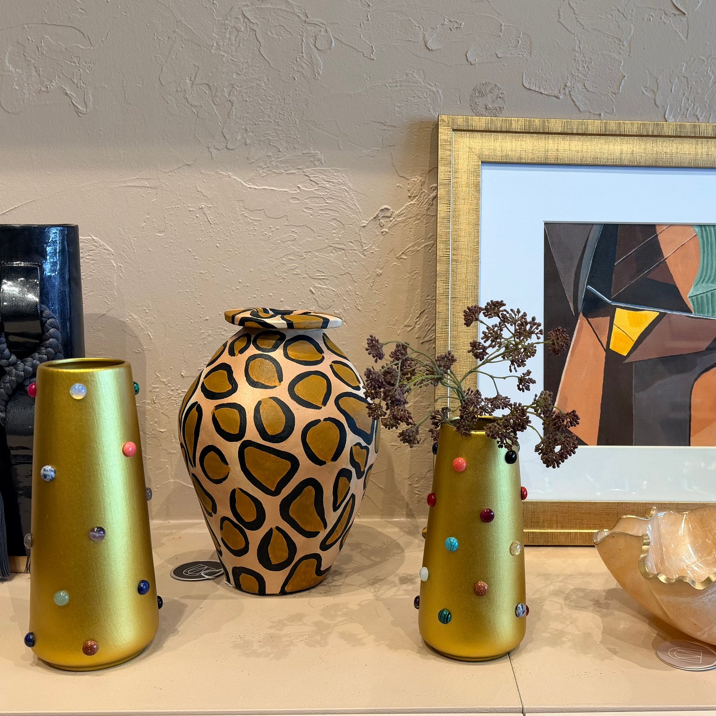Gold vase from P.Grunsfeld by The Vault Creative featuring a sleek, elegant design with a shiny finish and decorative details.