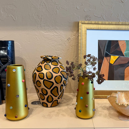 Gold vase from P.Grunsfeld by The Vault Creative featuring a sleek, elegant design with a shiny finish and decorative details.