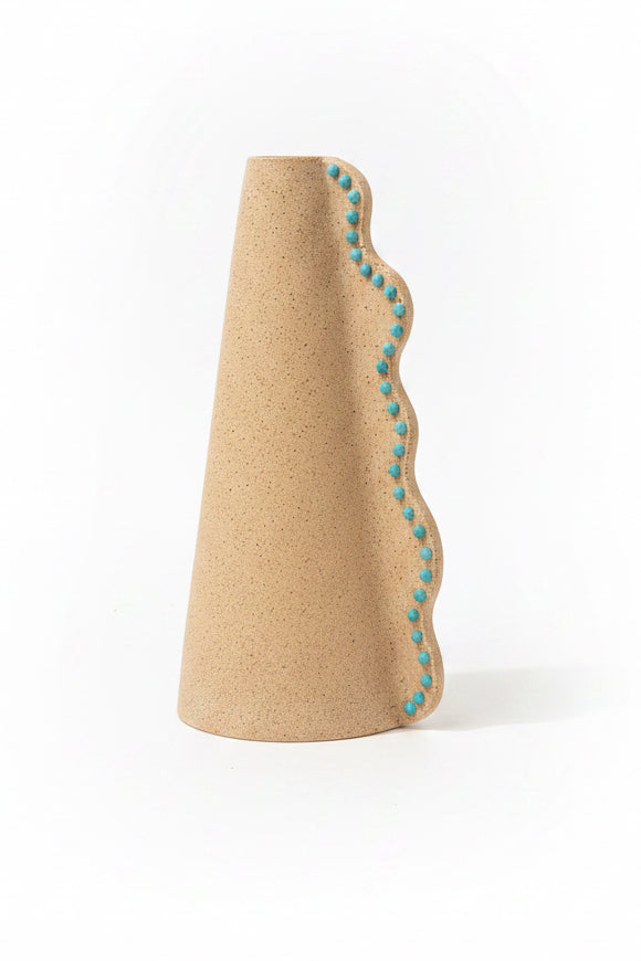 Ceramic wavy vase by P. Grunsfeld from The Vault Creative, featuring a textured surface and flowing wave design in neutral tones.