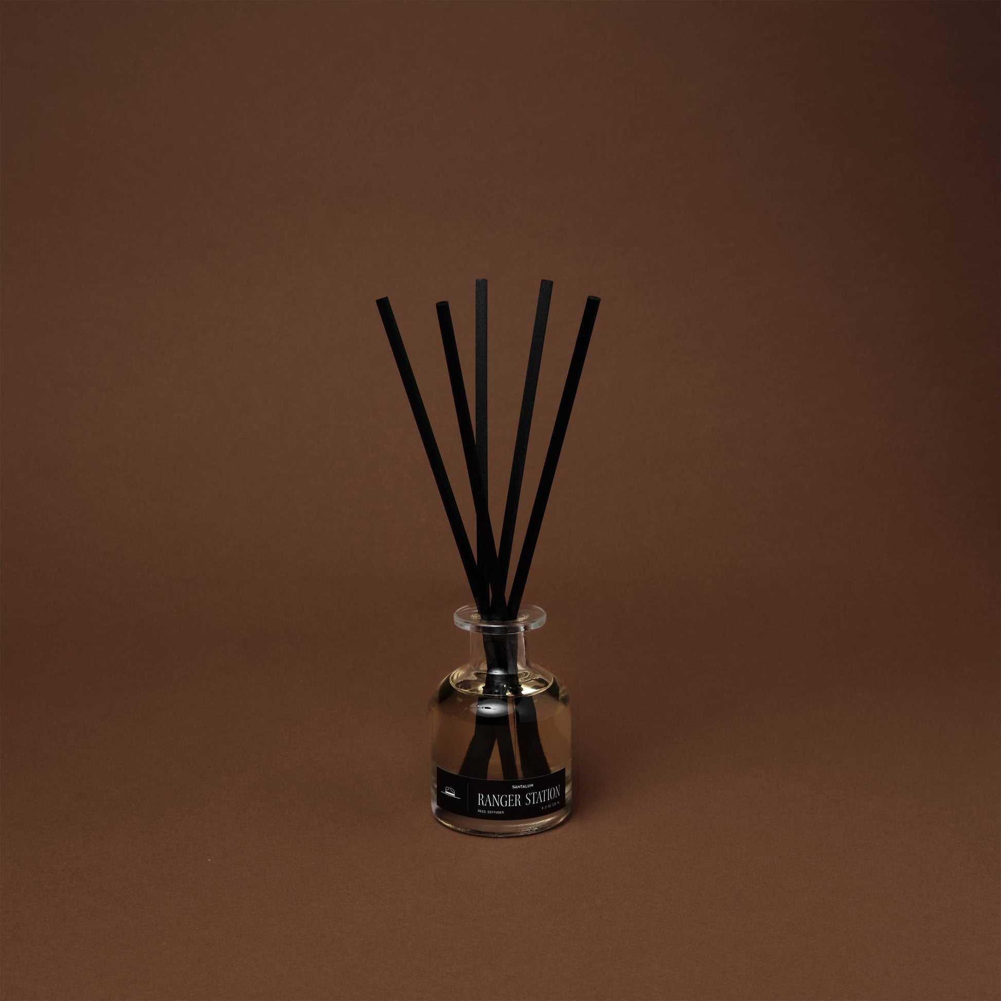 Santalum Reed Diffuser by Ranger Station Wholesale with natural reed sticks and a clear glass bottle containing scented oil.
