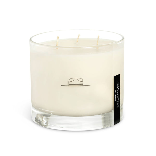 Ozmun Home Santalum Mammoth candle with a rustic wooden wick and natural wax, displayed on a wooden surface.