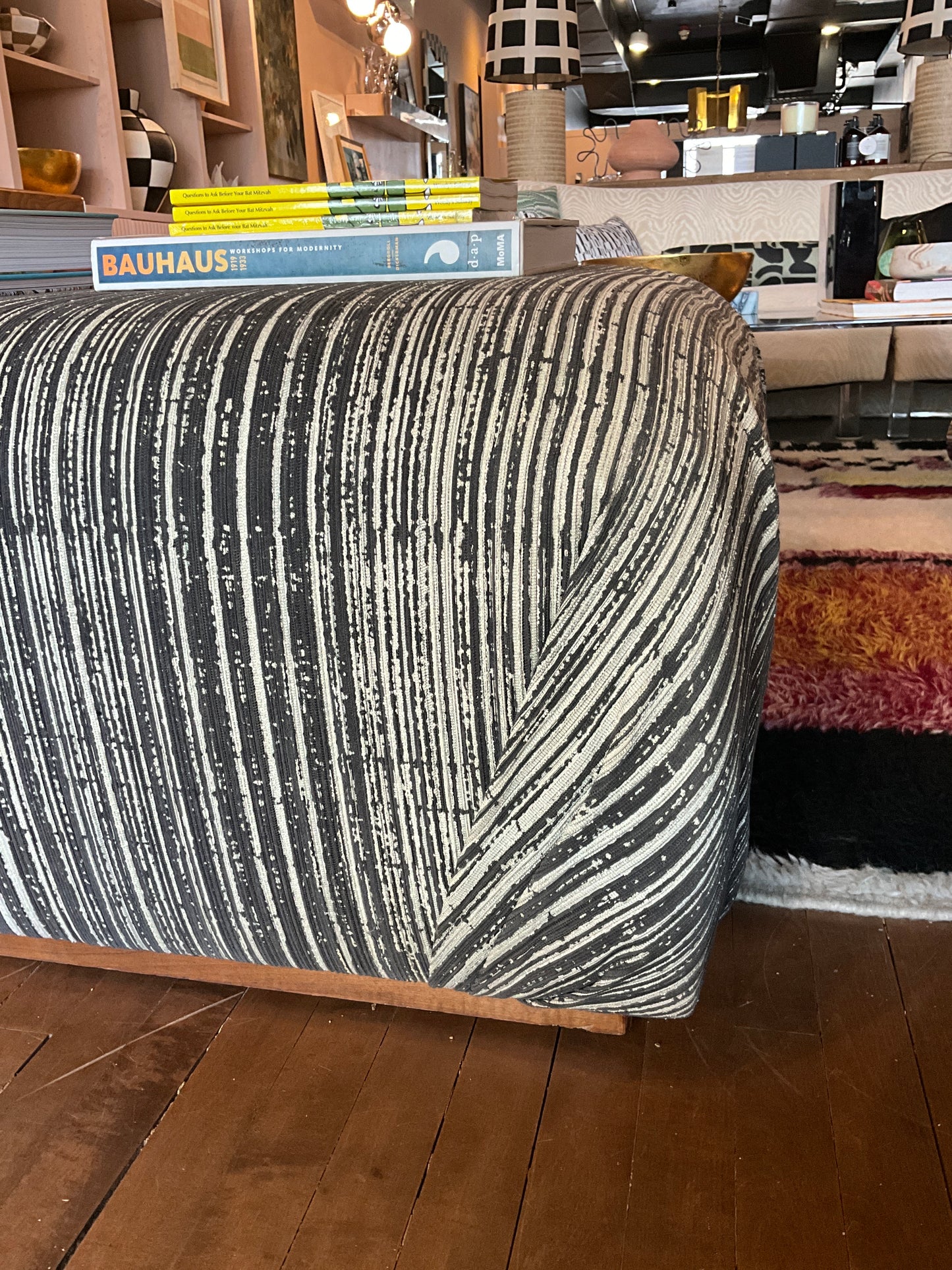 Vintage Ottoman Coffee Table by The Vault Creative featuring a wooden top and upholstered base with decorative nailhead trim.