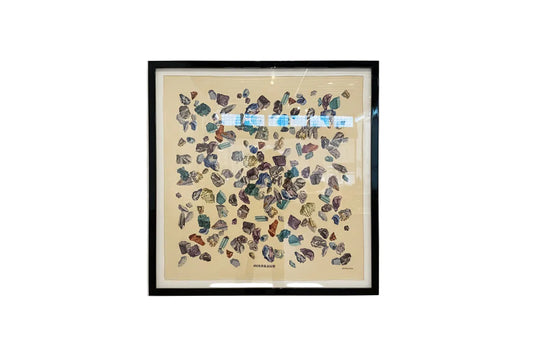 Framed vintage Hermes scarf displayed on a wall, showcasing intricate patterns and classic design in a stylish presentation.