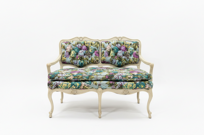 Small flower-patterned loveseat bench by The Vault Creative with cushioned seating and wooden legs.