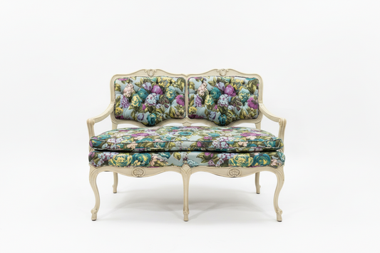 Small flower-patterned loveseat bench by The Vault Creative with cushioned seating and wooden legs.