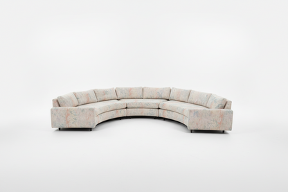 Vintage curved sofa by The Vault Creative, upholstered with plush fabric, featuring a stylish 1950s-inspired design.