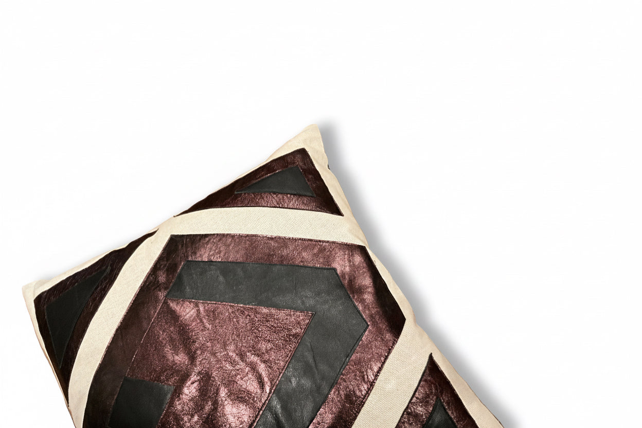 Leather patchwork pillow by The Vault Creative featuring mixed leather patches and a soft, textured fabric surface.