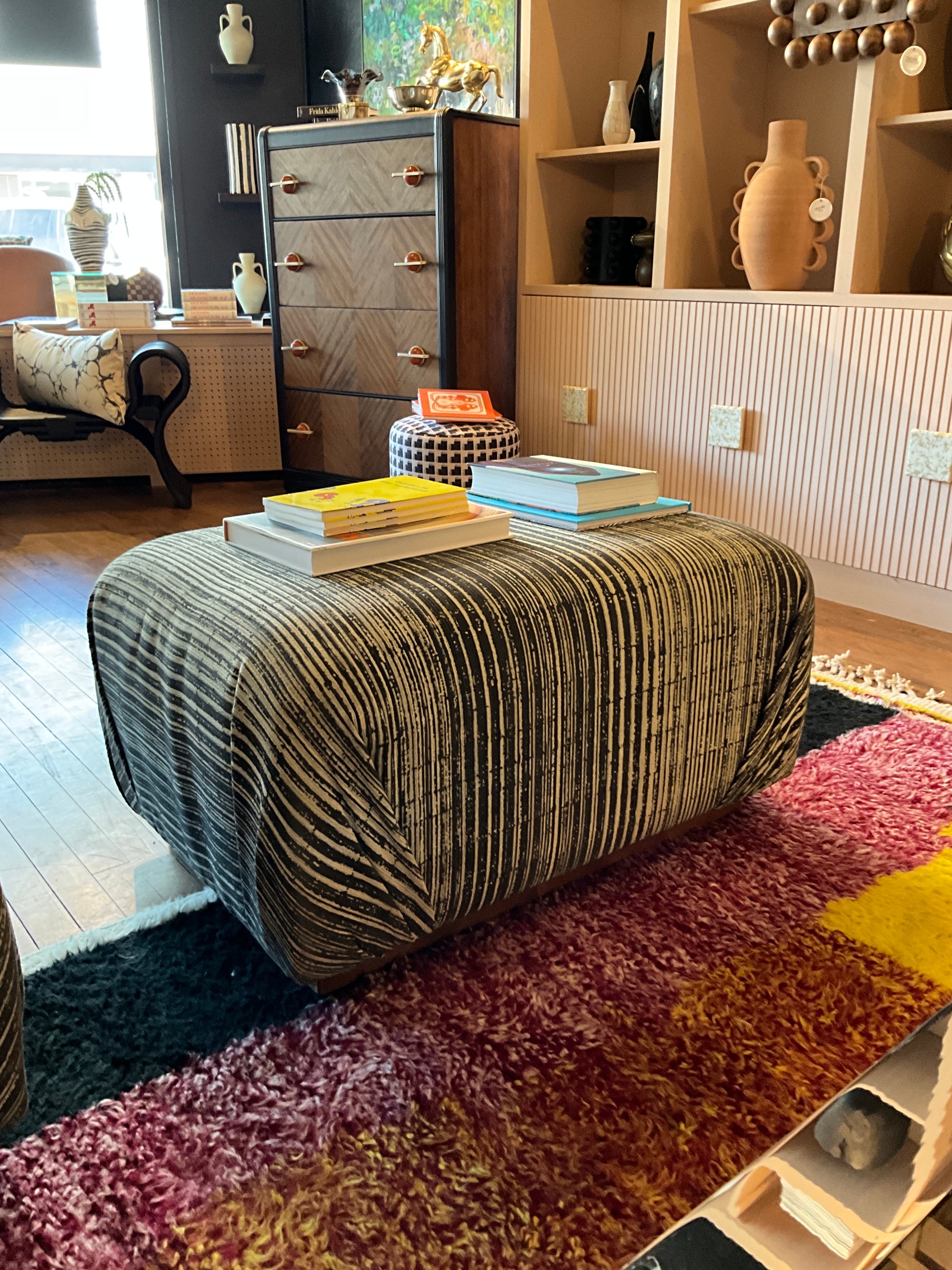 Vintage Ottoman Coffee Table by The Vault Creative showing a wooden upholstered ottoman with carved legs and vintage style.