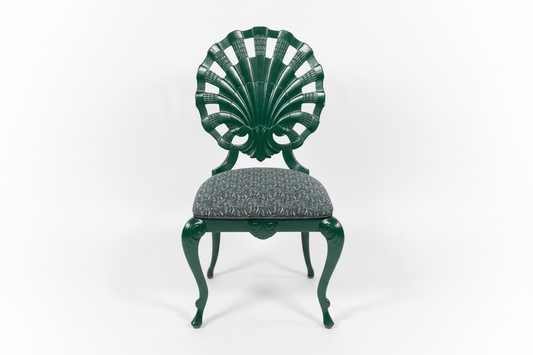 Green shell chair by The Vault Creative with smooth, curved design and wooden legs, modern and stylish for contemporary interiors.
