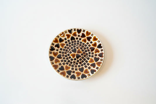 Colorful heart mosaic plate by The Vault Creative with intricate tile design and vibrant pattern on a ceramic surface.