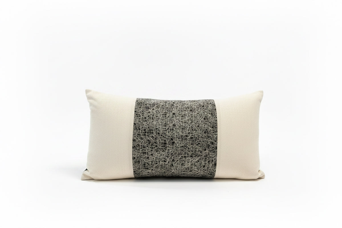Small lumbar pillow by Stone Textile with soft fabric cover, designed to provide lower back support and comfort.