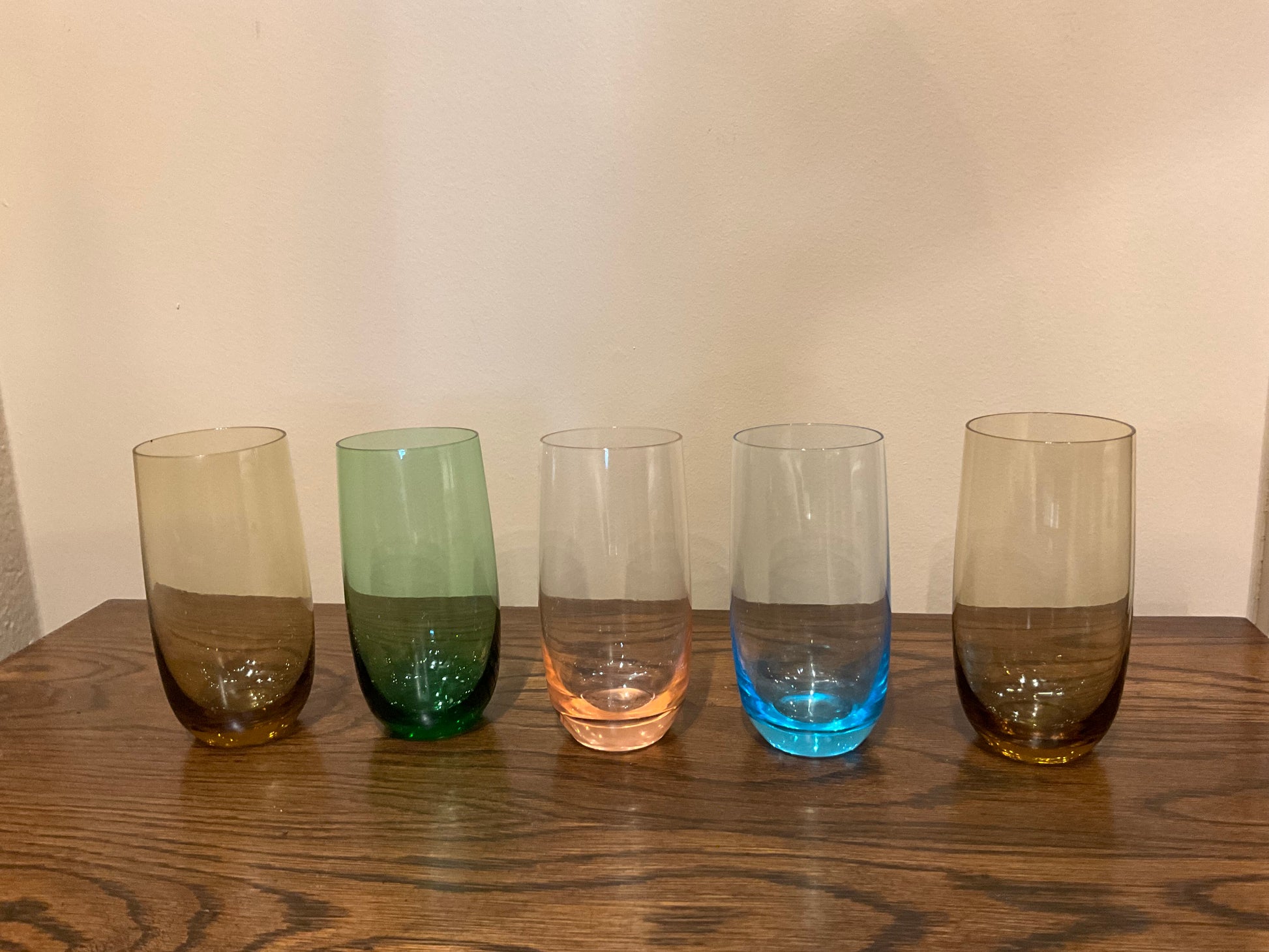 Five tall colored drinking glasses from The Vault Creative, featuring vibrant hues and clear glass design.