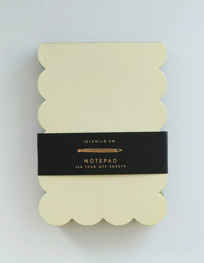 Chartreuse and olive scalloped-shaped notepad from Idlewild Co. with decorative edges, displayed on a flat surface.