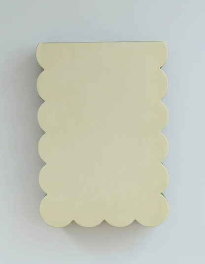 Scalloped shaped notepad with chartreuse and olive edge, Idlewild Co. logo on a white background with a decorative scalloped border.