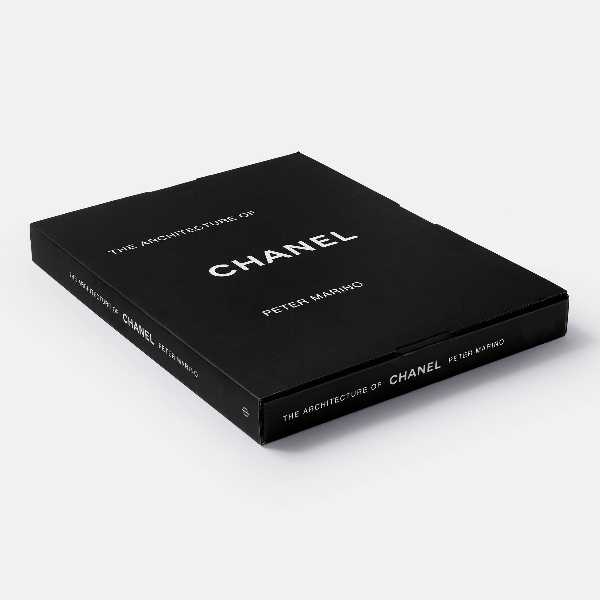 Open book titled "The Architecture of Chanel" by Phaidon, showing detailed black and white photographs of Chanel's architectural designs.
