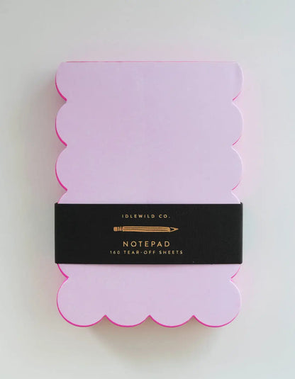 Scalloped shaped notepad with lilac and hot pink edges by Idlewild Co. featuring a decorative, scalloped design and colorful border.