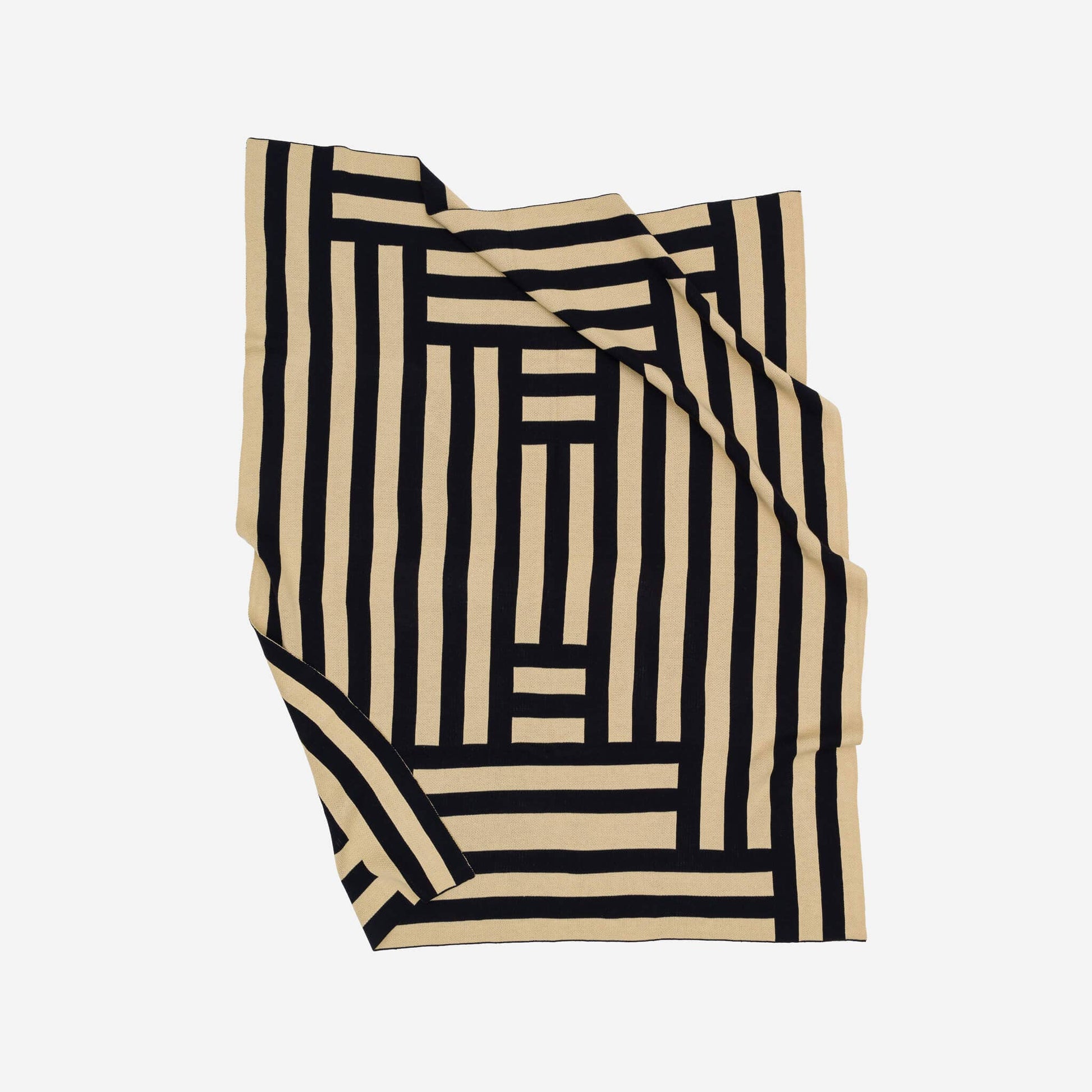 VERLOOP knits Columns Throw featuring a cozy, textured knit fabric with a striped pattern in neutral tones.