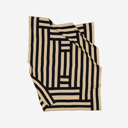 VERLOOP knits Columns Throw featuring a cozy, textured knit fabric with a striped pattern in neutral tones.