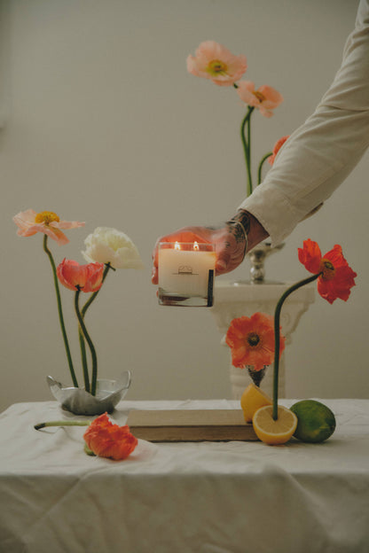Ozmun Home Superbloom Candle with floral design in a glass jar, featuring vibrant colors and intricate botanical artwork.