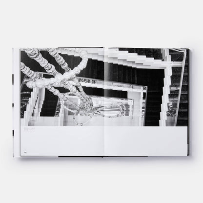Open book titled "The Architecture of Chanel" by Phaidon showing black-and-white interior images and architectural sketches.
